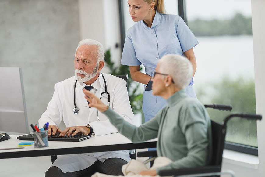Senior Doctor Consulting with Elderly Patient and Nurse