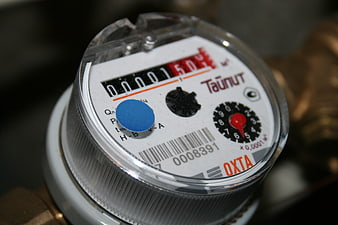 Close-up of a mechanical water meter with digital counter