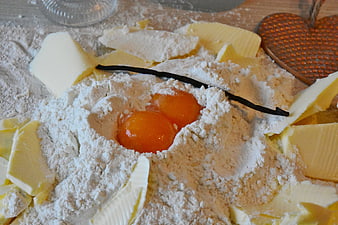 Baking ingredients with flour, butter, eggs, and vanilla pod