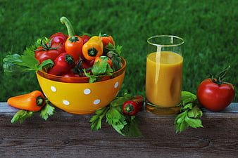 Fresh vegetable juice with tomatoes and peppers in a yellow bowl