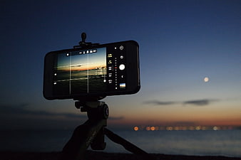 Smartphone on Tripod Filming Sunset Over Ocean
