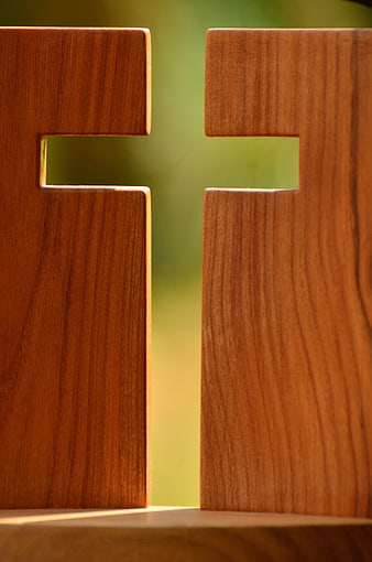 Close-up of wooden cross with green background