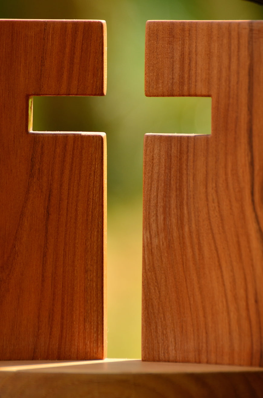 Close-up of wooden cross with green background