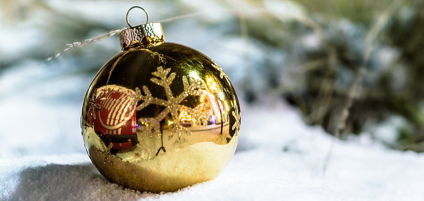 Golden Christmas Ornament in Snow with Snowflake Design