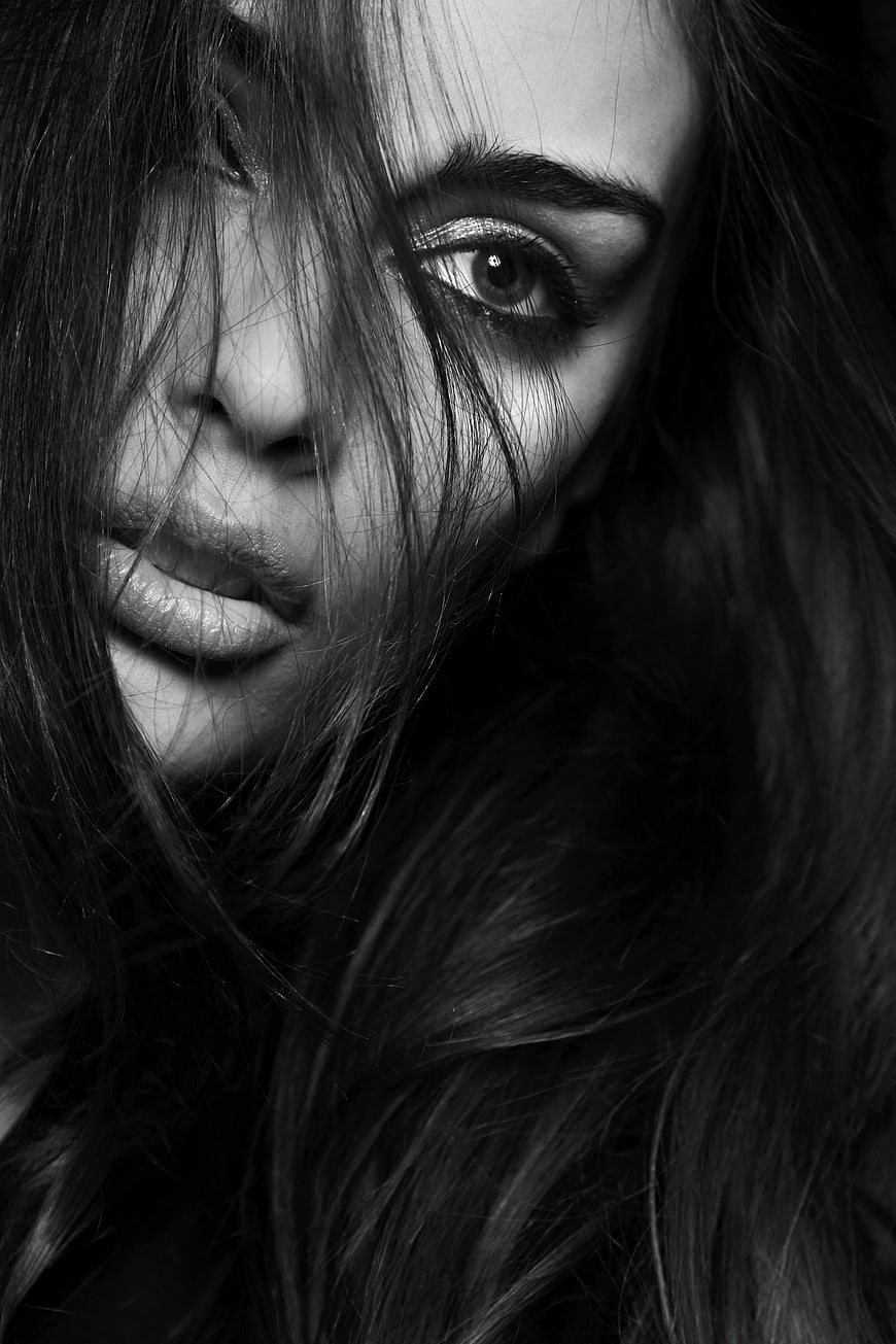 Black and white close-up portrait of a woman with messy hair