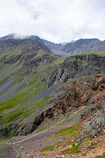 Rugged mountain landscape with rocky terrain and green slopes
