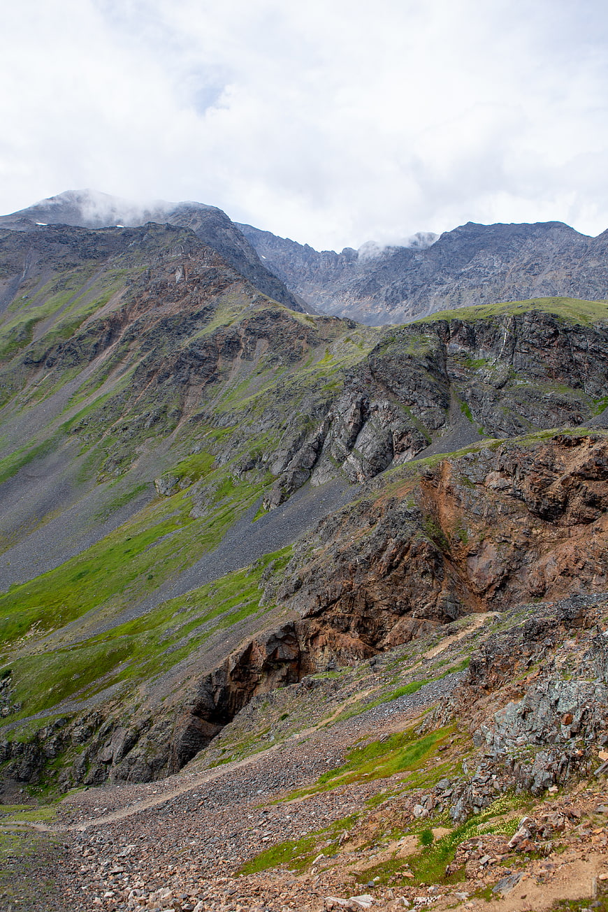 Rugged mountain landscape with rocky terrain and green slopes