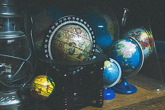 Vintage globes and lantern on wooden desk