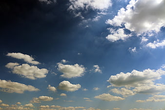 Dramatic Blue Sky with Sunbeams and Fluffy White Clouds