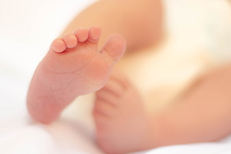 Close-up of baby feet on white background