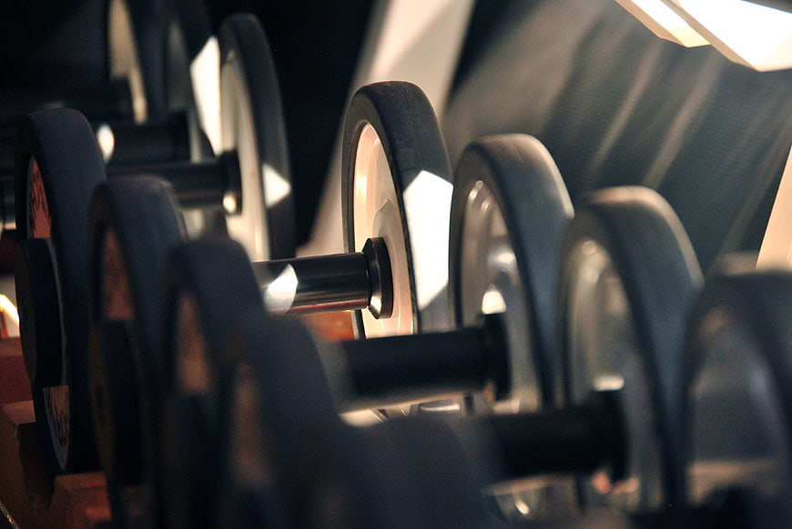 Close-up of black dumbbells on a rack in a gym