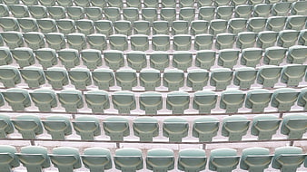 Rows of empty green stadium seats in an auditorium