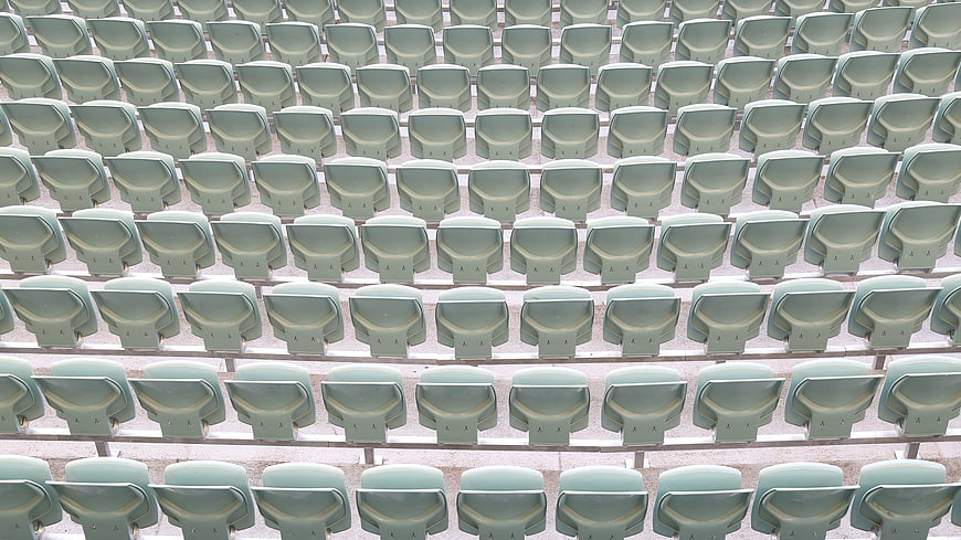 Rows of empty green stadium seats in an auditorium