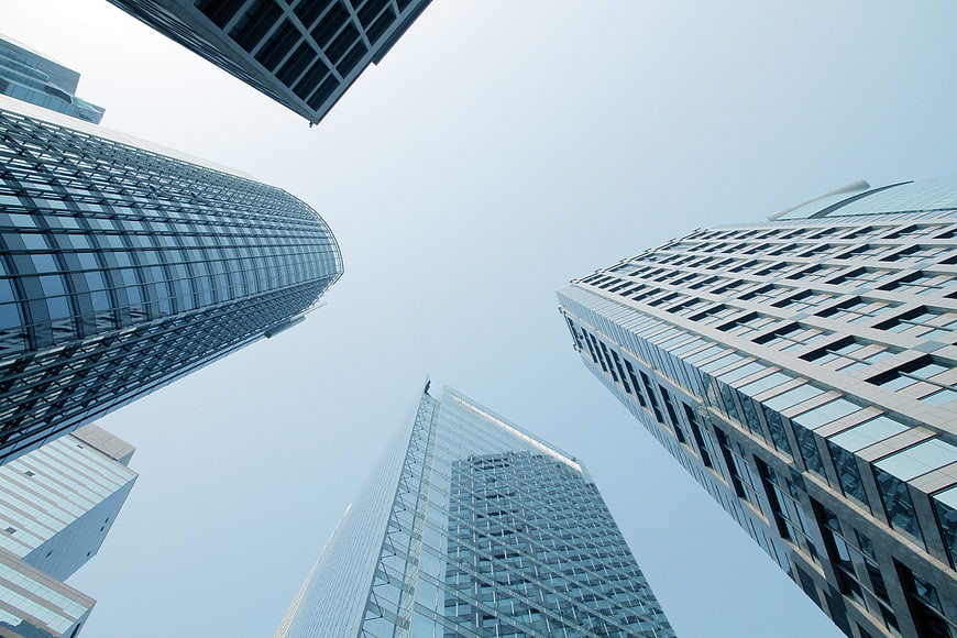 Low angle view of modern glass skyscrapers against a clear blue sky