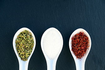 Three Spoons with Green Tea, Salt, and Saffron on Dark Background