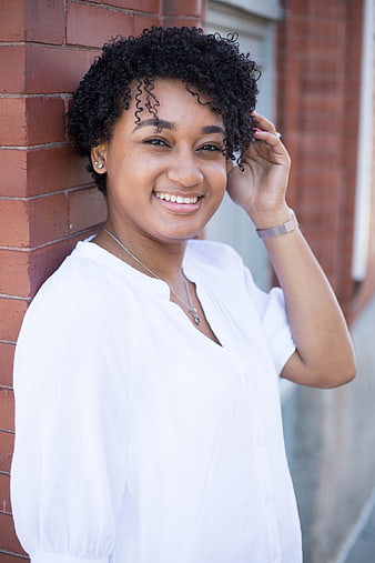Smiling Young Black Woman Portrait Against Brick Wall