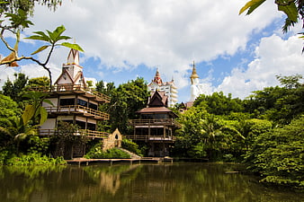 Thai temple complex with white Buddha statue and lake