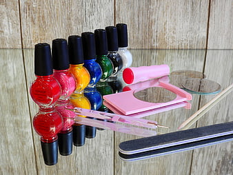 Colorful nail polish bottles and manicure tools on glass table