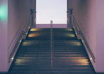 Symmetrical concrete stairs with neon lighting at dusk