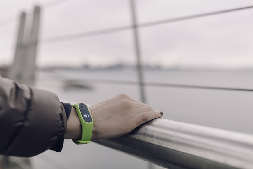 Woman Wearing Green Fitness Tracker on Bridge