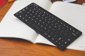 Black wireless keyboard on open notebook