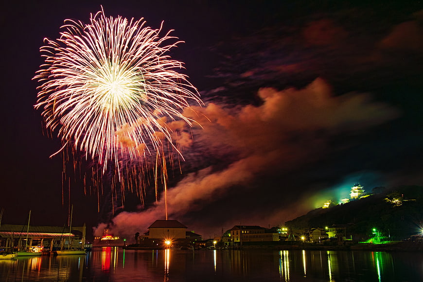Spectacular Fireworks Display Over Japanese Harbor at Night