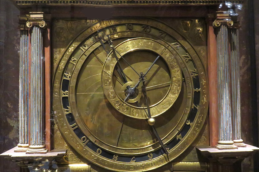 Antique brass astronomical clock with intricate dials and columns