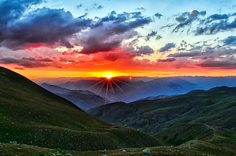 Vibrant Sunrise Over Rolling Green Mountain Ridges