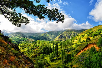 Lush Green Mountain Valley Landscape With Blue Sky And Clouds