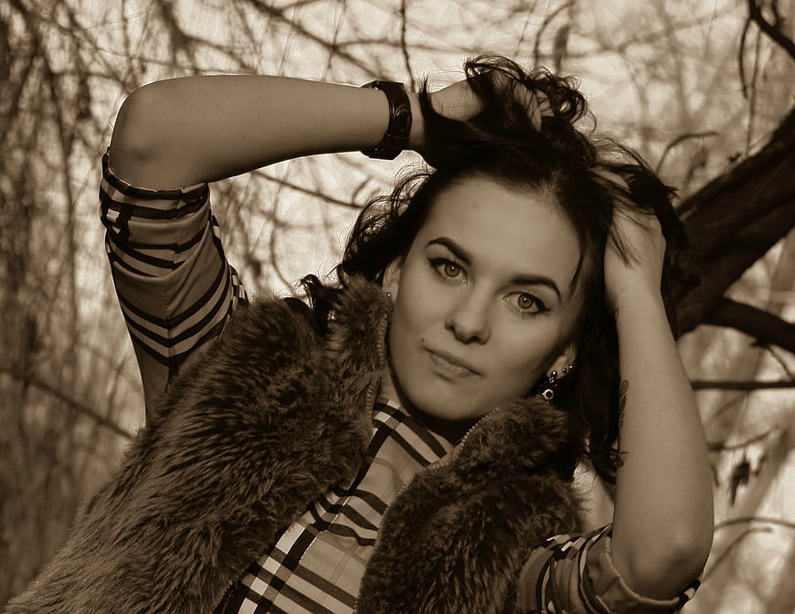 Sepia Portrait of Woman in Fur Vest in Woods