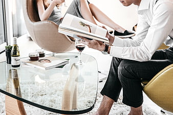 Couple relaxing in modern living room with wine and books