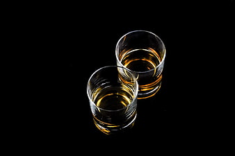 Two Glasses of Amber Liquor on Black Background