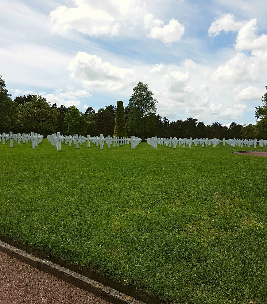 Rows of white crosses in a military cemetery on a sunny day