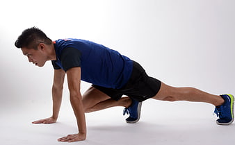 Male Athlete Performing Mountain Climber Exercise In Studio