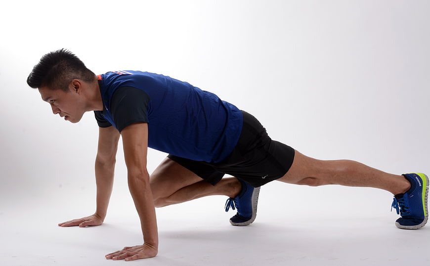 Male Athlete Performing Mountain Climber Exercise In Studio