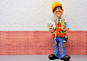 Construction worker figurine with blueprints and tools
