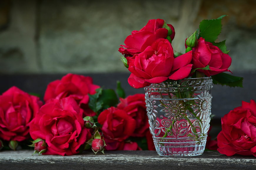 Red Roses in Vintage Glass Vase on Wooden Table