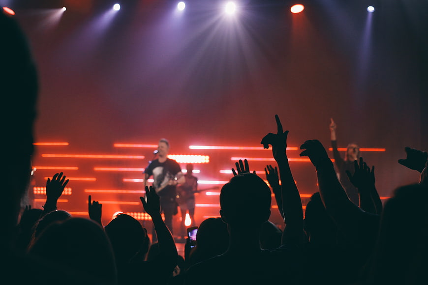 Silhouette of concert crowd cheering at live music performance