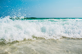 Dynamic Ocean Wave Splash on Sunny Beach Shore