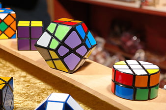 Assorted Twisty Puzzle Cubes Displayed On Wooden Market Shelf