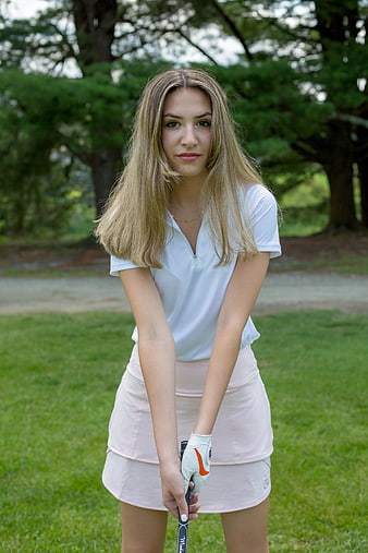Young Female Golfer Holding Club on Green Course