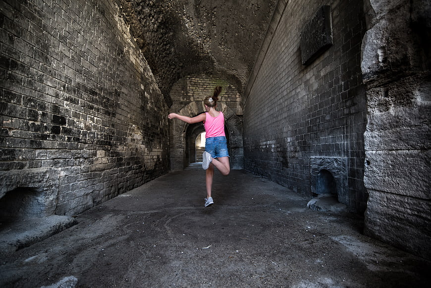 Woman stretching in ancient stone tunnel