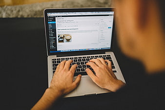 Hands typing on laptop creating new blog post