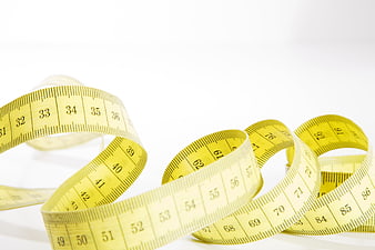 Yellow Sewing Measuring Tape Coiled on White Background