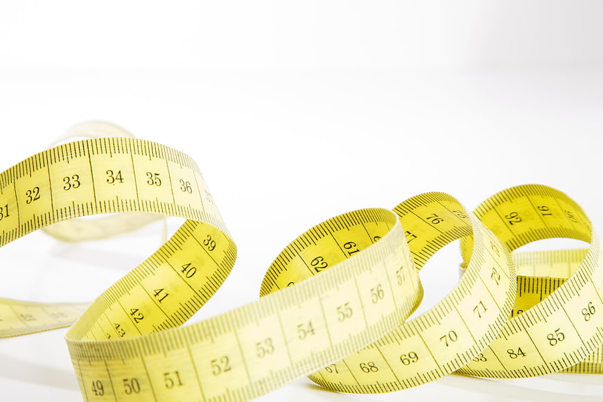 Yellow Sewing Measuring Tape Coiled on White Background
