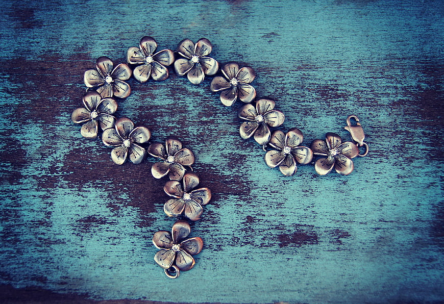Silver Flower Bracelet On Textured Blue Wooden Surface
