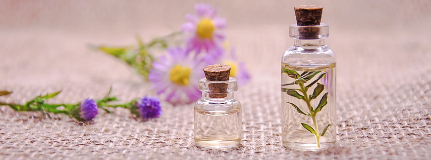 Essential Oil Bottles with Herbs and Wildflowers on Burlap