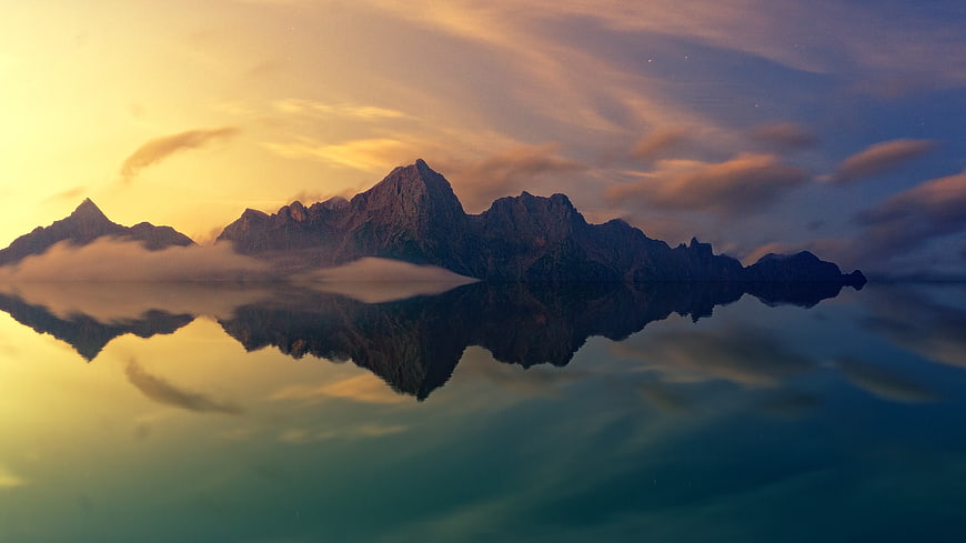 Majestic Mountain Range Reflection in Calm Lake at Sunset