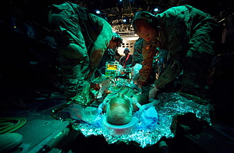Military medics treating patient in aircraft interior