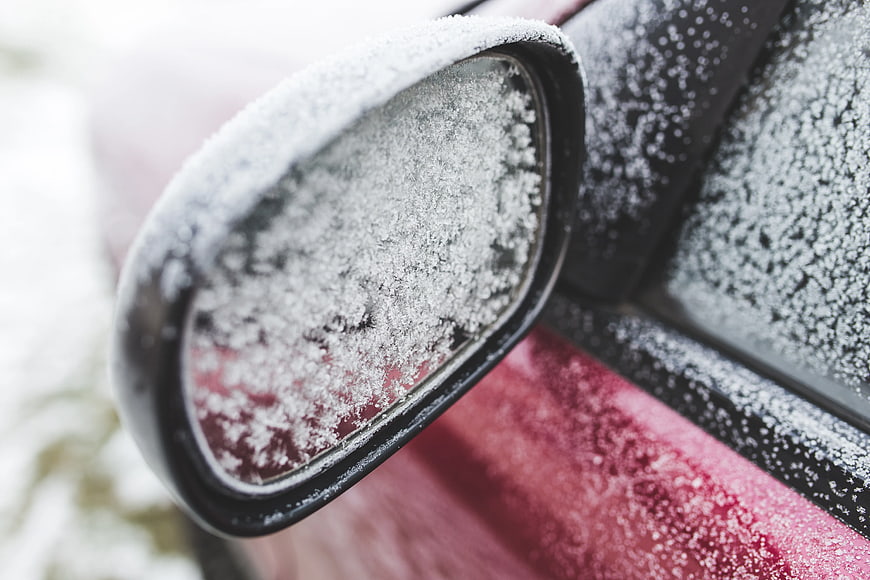 Close-up of frost-covered car side mirror in winter